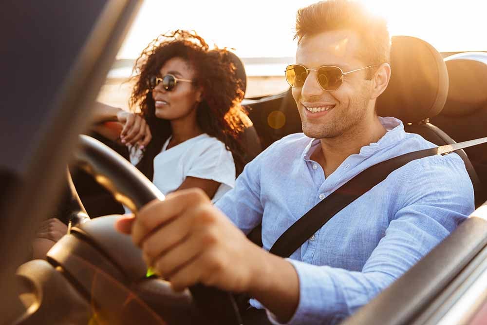 Man and woman driving in a convertible