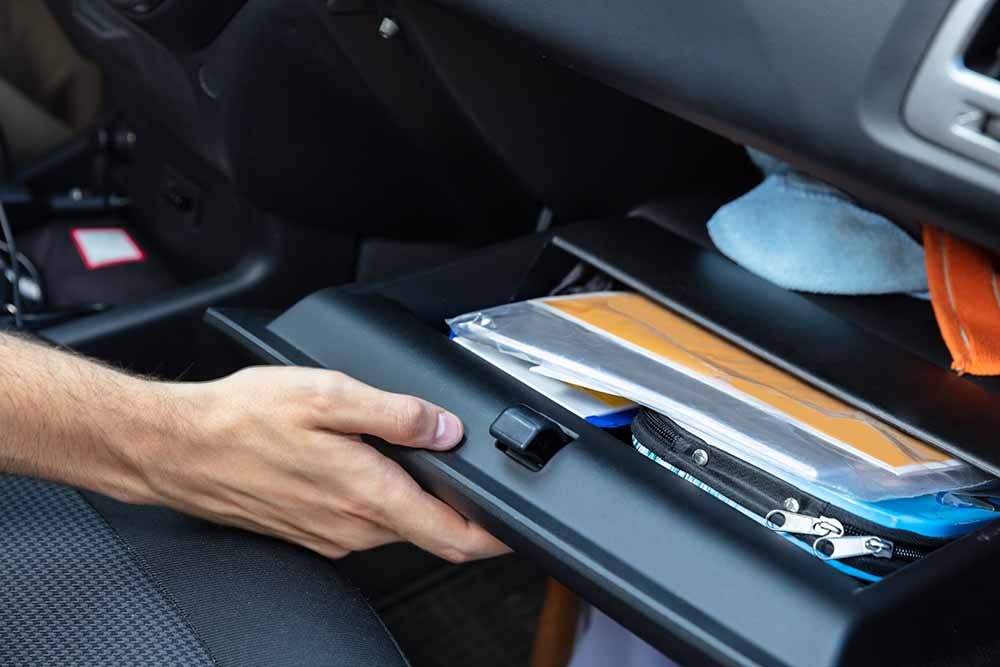 Un automobiliste ouvre le coffre à gants de sa voiture