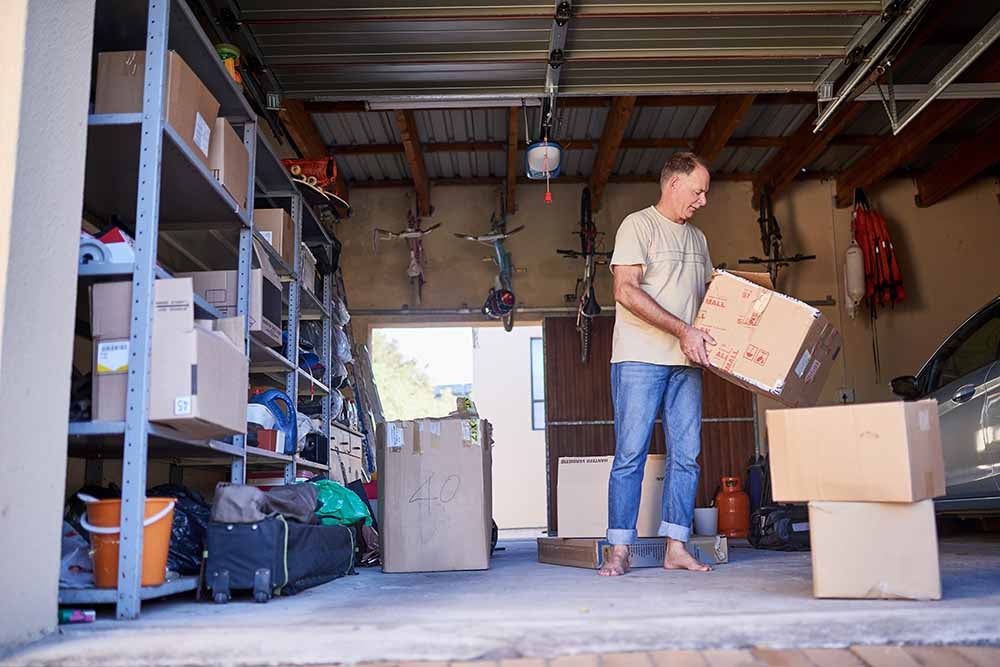 Shot of a man carrying a box in a garage.