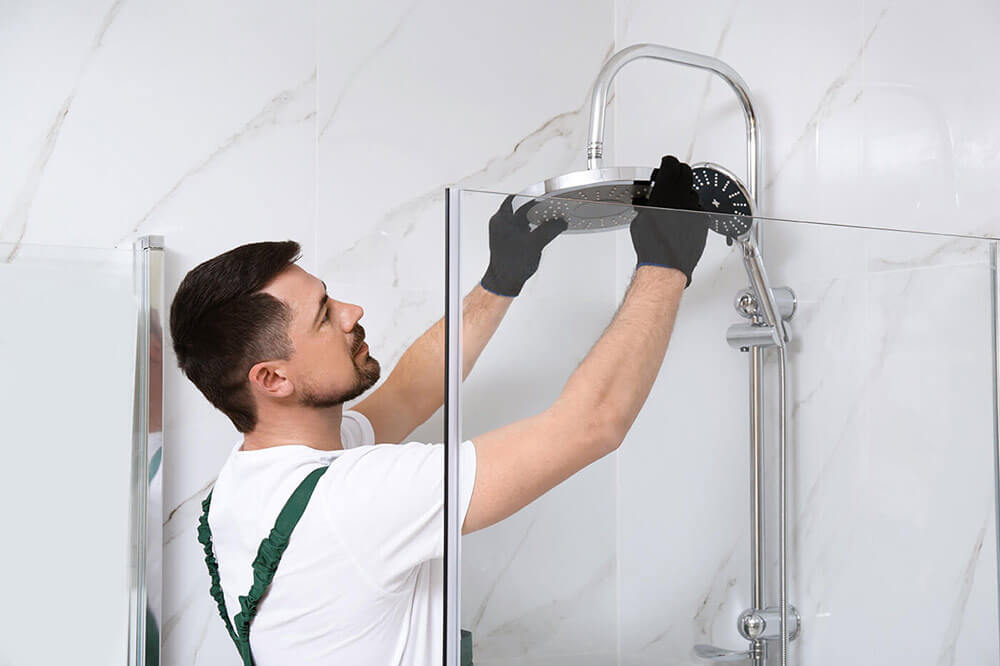 Homme changeant une pomme de douche