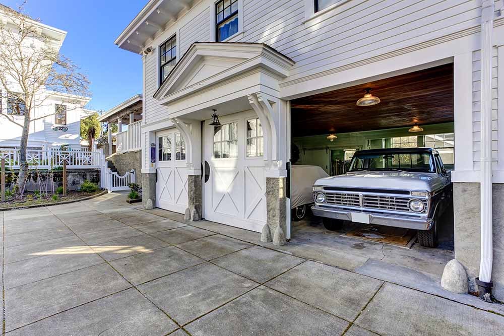 House exterior. Three door garage with car and driveway