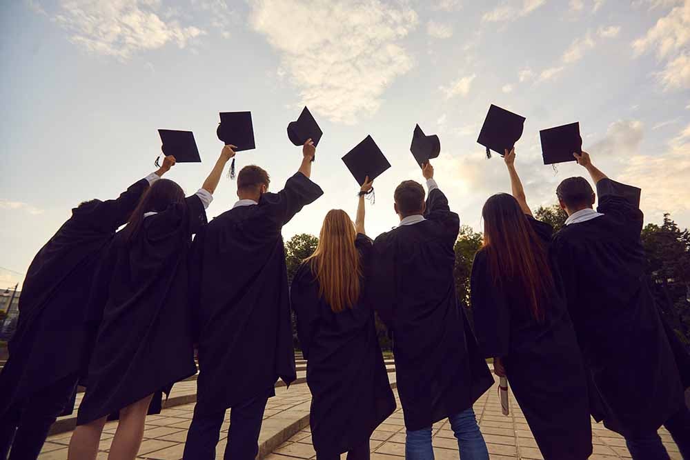 Des diplômés universitaires lancent leur toque en l'air