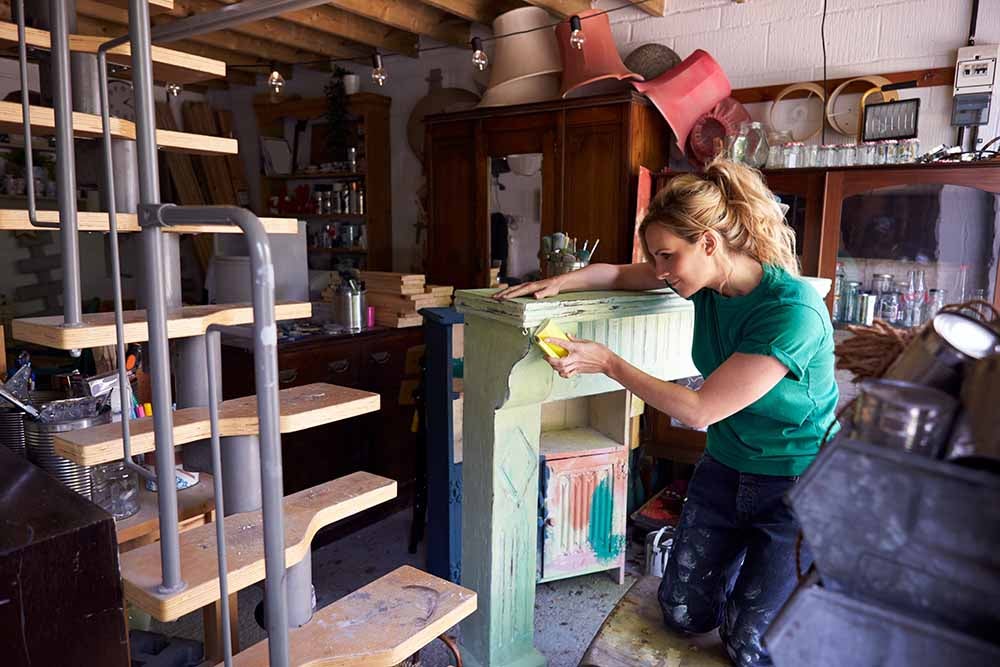 Femme qui recycle de vieux meubles