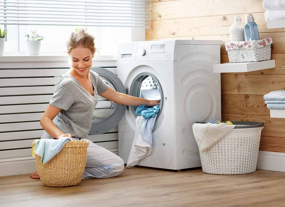 Femme mettant une brassée dans la laveuse