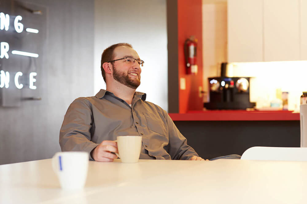 Homme avec une tasse de café assis à une table