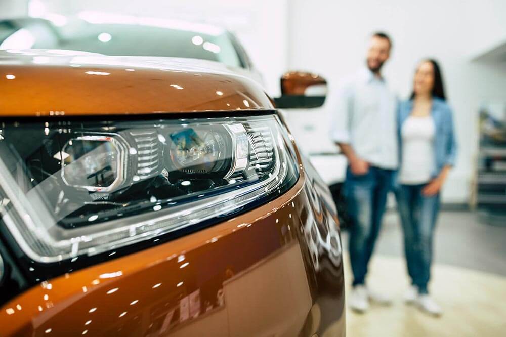Jeune couple regardant une voiture