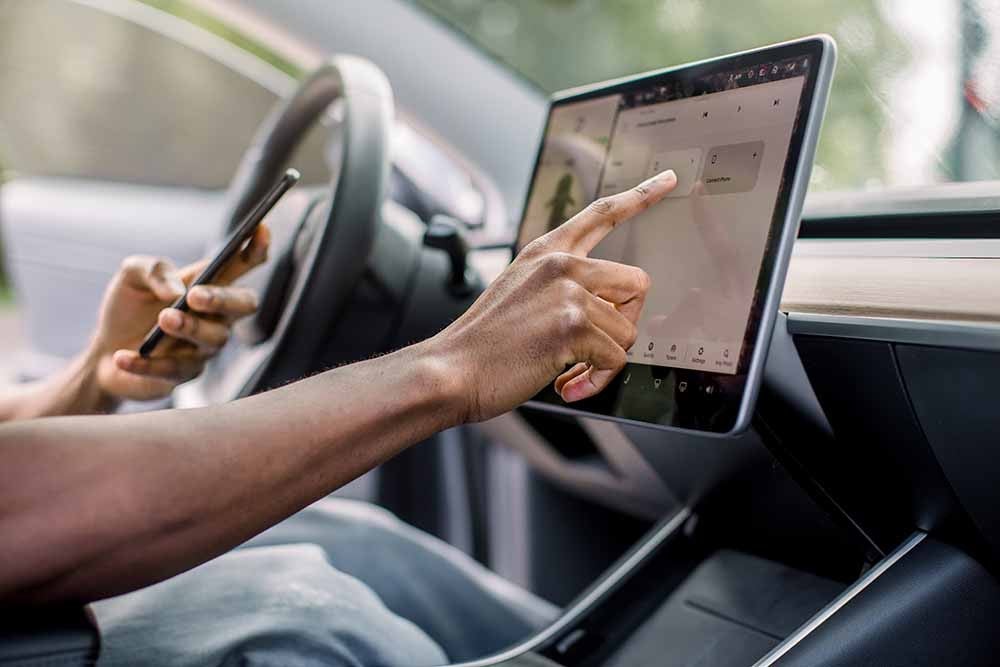 Une personne règle les fonctions de sa voiture au moyen d'un téléphone intelligent