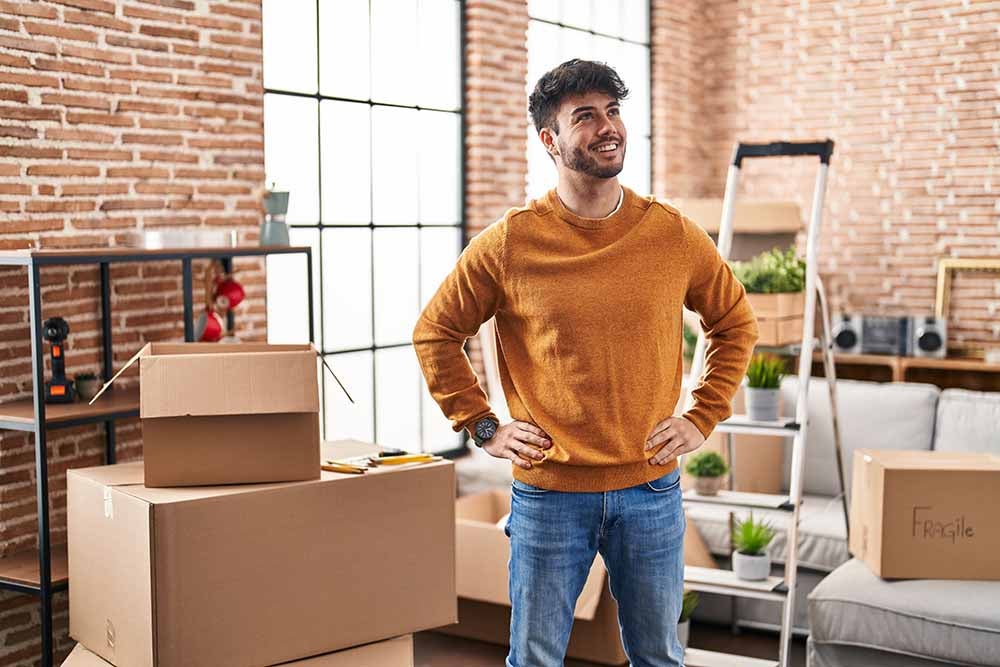Un jeune homme aménagement dans son appartement
