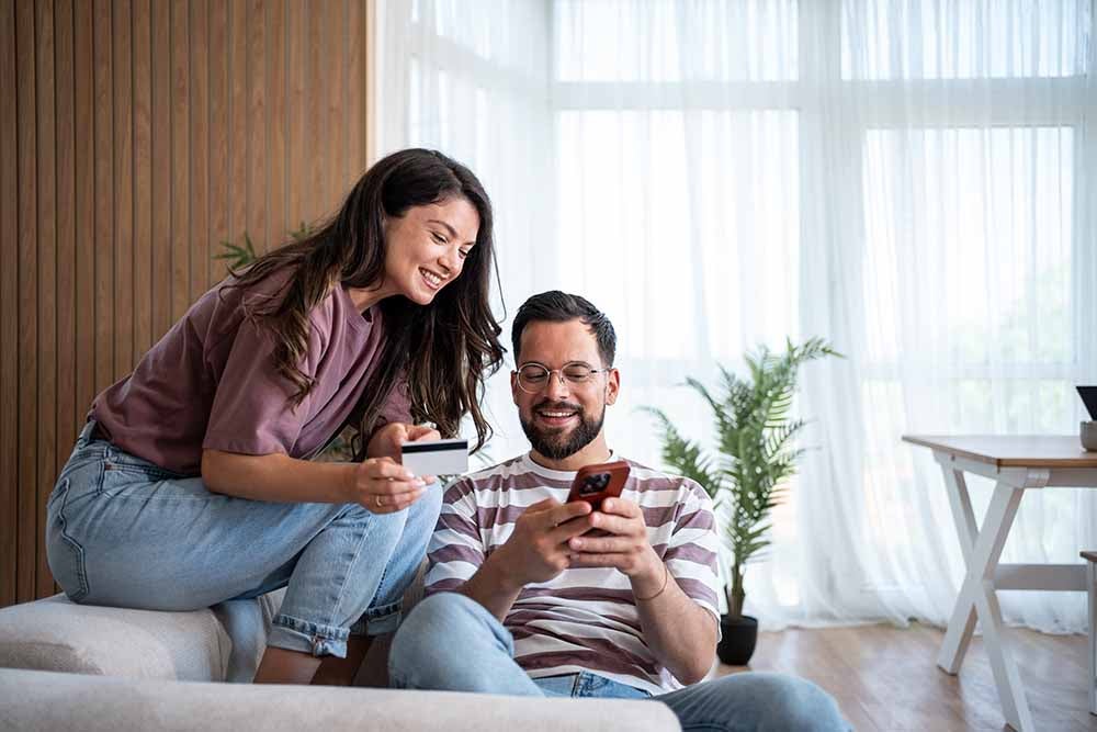 Un jeune couple effectue des op├⌐rations bancaires en ligne