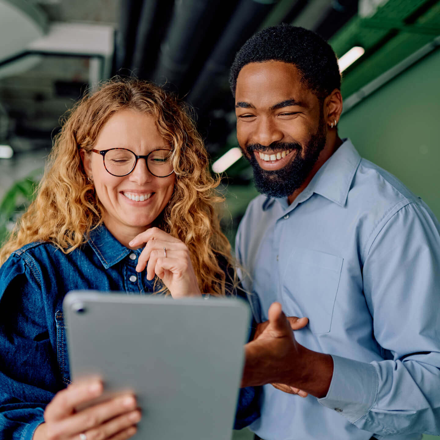 Deux collègues qui révisent leur travail sur une tablette.