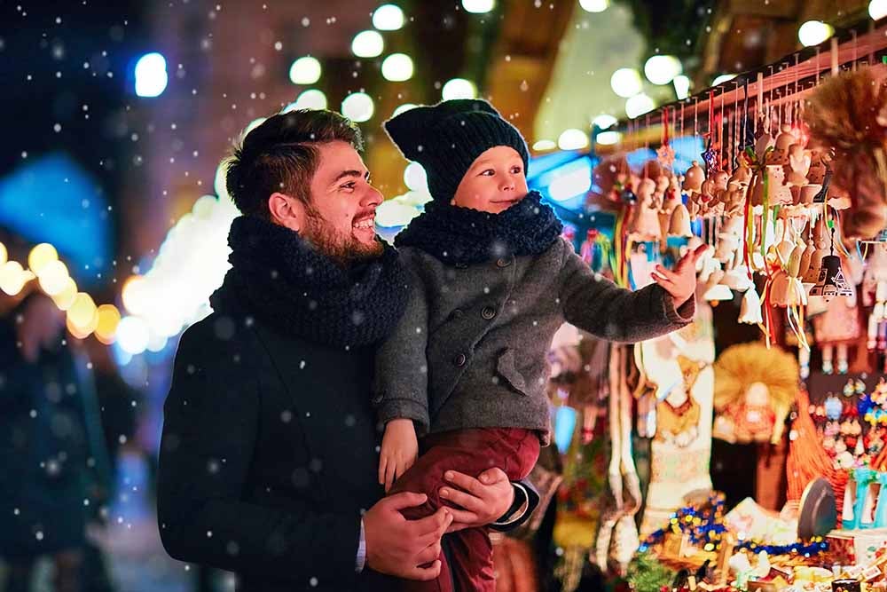 Father and young son at a holiday market