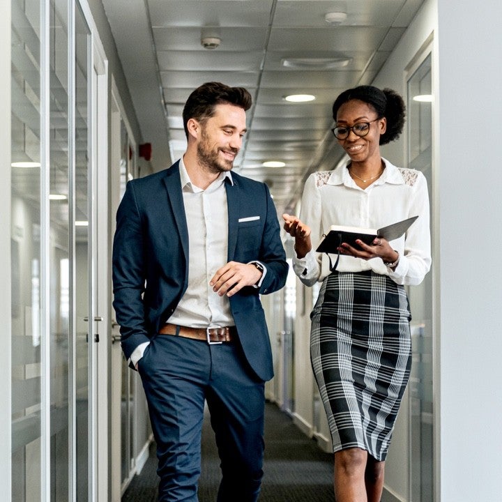 Professionals in an office talking about home and auto insurance