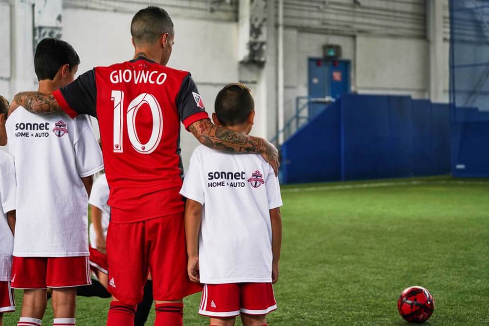Giovinco de la TFC avec des enfants qui jouent au soccer