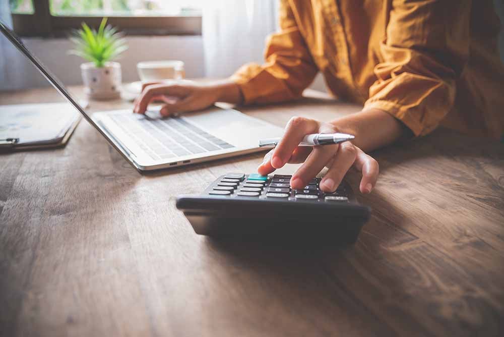 Une femme effectue des calculs à un bureau