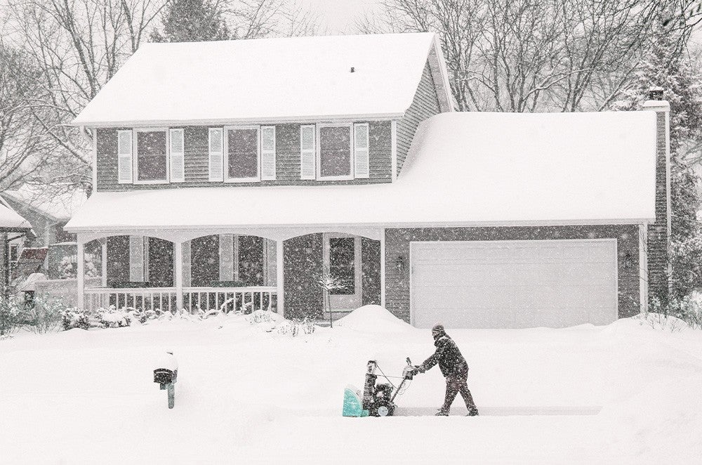 Un homme utilise une souffleuse à neige