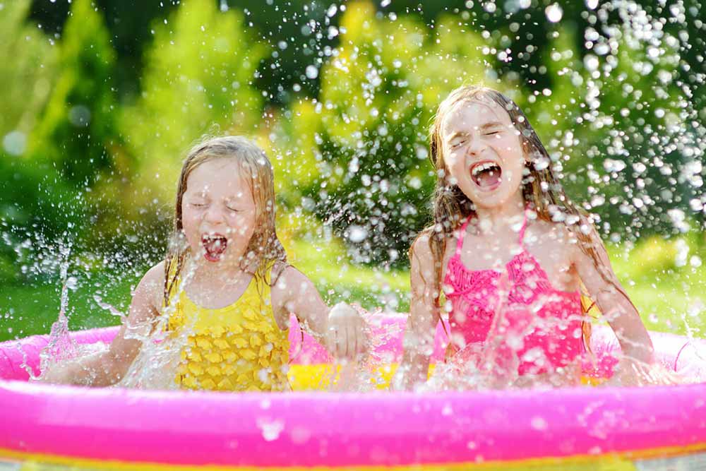 Deux filles qui s'éclaboussent dans une piscine gonflable
