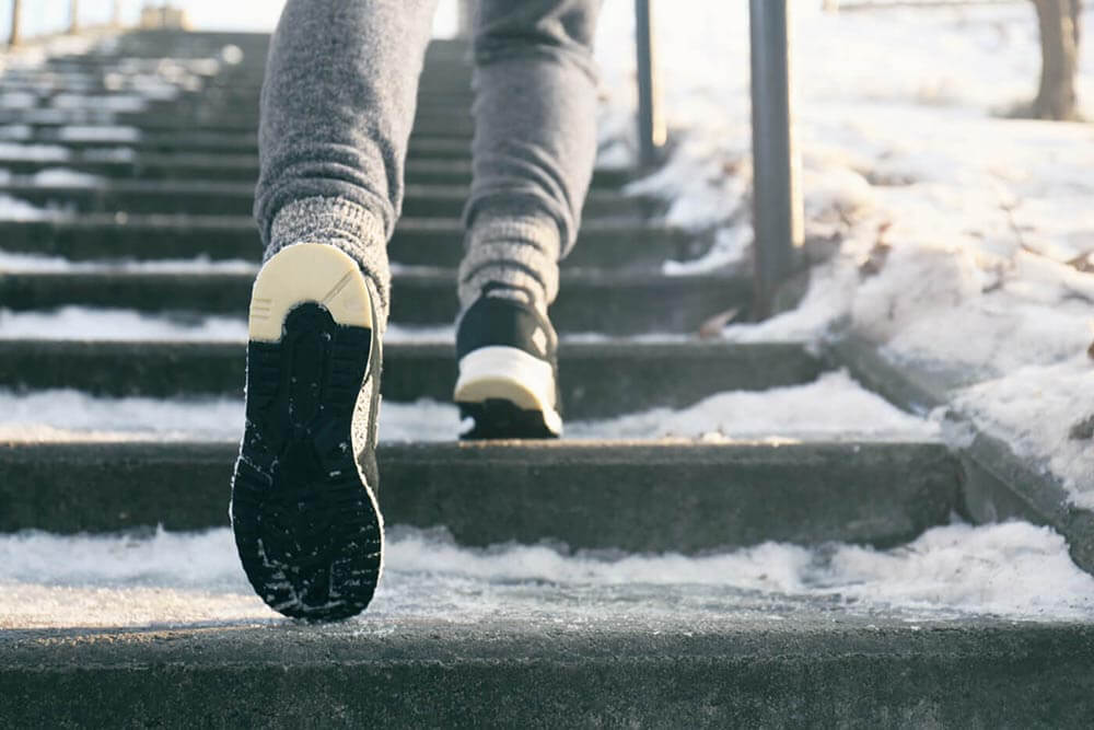 Pieds d'une personne sur des marches glacées
