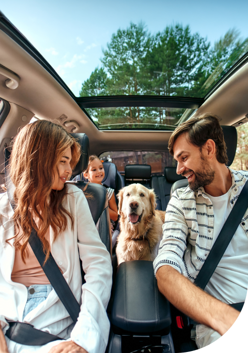 A happy family with a dog driving an insured car in Ontario.