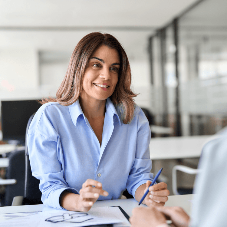Une femme assise à un bureau.