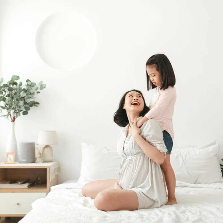 Mère et fille riant sur le lit