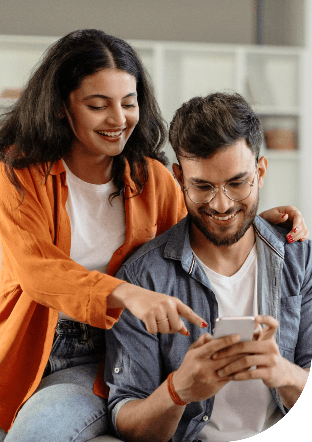 Un couple est heureux d’utiliser leur téléphone intelligent pour obtenir une soumission d’assurance habitation en ligne.