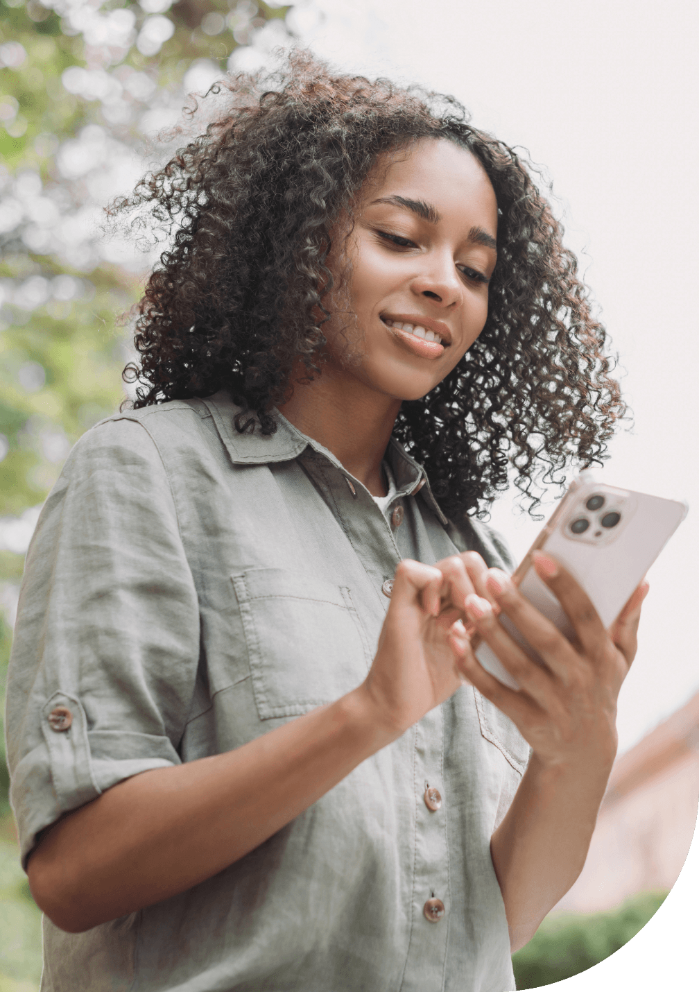 Young woman buying insurance on their mobile phone online while taking a leisurely walk in the park.