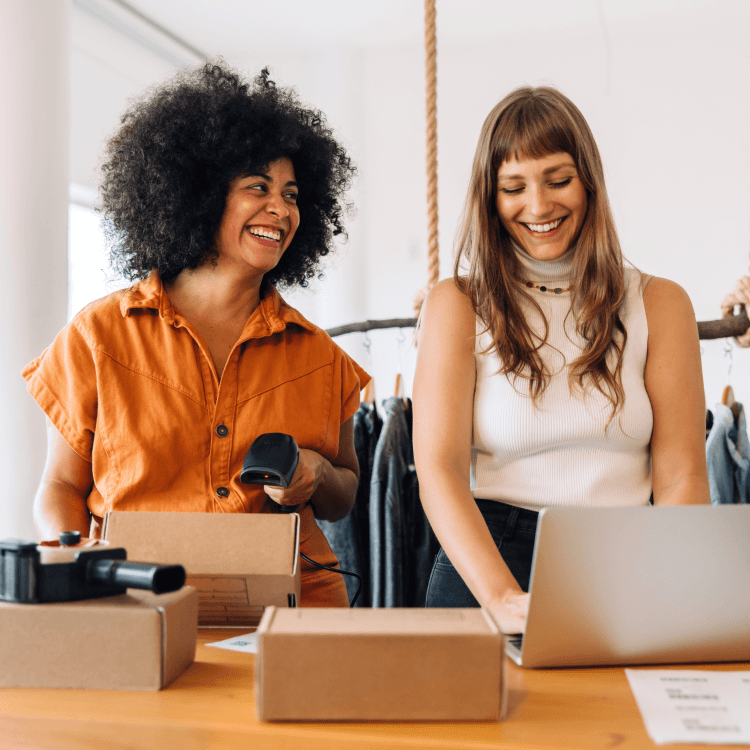 Two women smiling and collaborating at work.